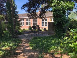 une maison avec une table et des chaises dans la cour dans l'établissement Schuringse Klasse, à Numansdorp