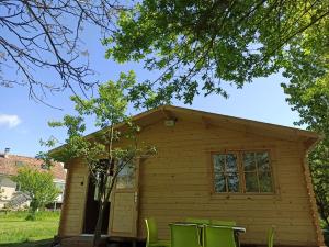 a tiny house with green chairs in front of it at Verton, Gîte Les chalets du Fliers Meublés de tourisme classés 2 étoiles plage de BERCK SUR MER in Verton