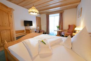 una camera con un grande letto bianco di Gasthof Mayrwirt a Saaldorf