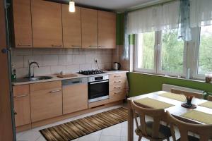 uma cozinha com armários de madeira e uma mesa com uma sala de jantar em Apartament Arkoński em Szczecin