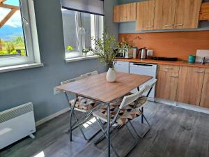 a kitchen with a table with chairs and a vase on it at Pokoje Gościnne Karkonosze in Wojcieszyce