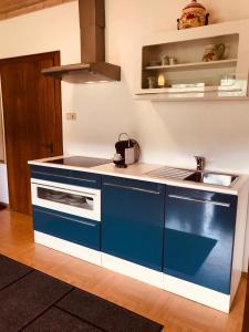 eine blau-weiße Küche mit einem Waschbecken in der Unterkunft Ferienwohnung Resi mit traumhaftem Seepanorama in Steindorf am Ossiacher See