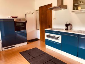 a blue and white kitchen with a stove top oven at Ferienwohnung Resi mit traumhaftem Seepanorama in Steindorf am Ossiacher See