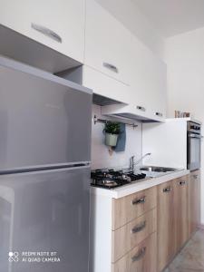 a white kitchen with a stove and a sink at APPARTAMENTO SANTUCCI in Rodi Garganico