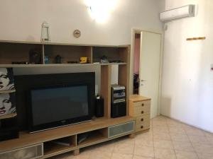 sala de estar con TV de pantalla plana en un centro de entretenimiento en Relax Torre lapillo, en Torre Lapillo