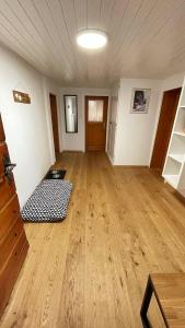 ein leeres Wohnzimmer mit Holzböden und einer Decke in der Unterkunft Bi de Furre in Reckingen - Gluringen
