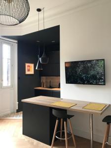 a kitchen with a counter and a table with stools at Studio 329 in Aix-les-Bains +28 photos