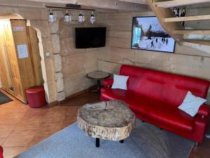 a living room with a red couch and a table at Góralski Domek Jasinek in Zakopane