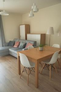 uma sala de estar com uma mesa e cadeiras e um sofá em Czartoryskiego 32 em Breslávia