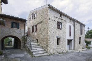 un antiguo edificio de piedra con escaleras delante en B&B Appartamento - IL RIONE, en Loreto Aprutino