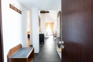 a hallway with a wooden table and a living room at Hotel Astoria am Urachplatz in Stuttgart