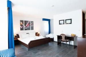 a bedroom with a bed and a desk and a table at Hotel Astoria am Urachplatz in Stuttgart