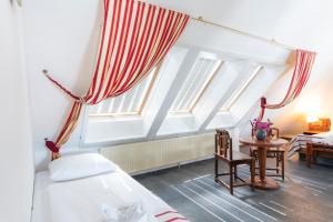 a attic room with a bed and a window at Hotel Astoria am Urachplatz in Stuttgart