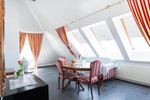 a dining room with a table and chairs and windows at Hotel Astoria am Urachplatz in Stuttgart