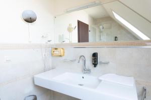 a bathroom with a sink and a mirror at Hotel Astoria am Urachplatz in Stuttgart