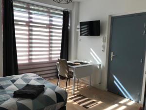 Appartements du Vally - Guingamp في غينغامب: غرفة نوم بسرير ومكتب ونافذة
