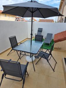 リベイラにあるApartamento en Rías Bajas. Ribeiraのテーブルと椅子、バルコニー(パラソル付)