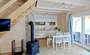 a kitchen and dining room with a wood stove at Sosnowe Wzgórze in Pasym