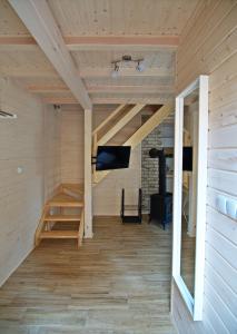 a room with a loft with a woodburning stove at Sosnowe Wzgórze in Pasym
