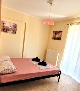 a bedroom with a bed with a pink blanket at Coralli Apartment in Khalkoútsion