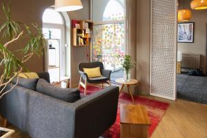 a living room with a couch and two chairs at Hôtel Marin in Laval