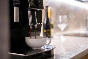 a coffee maker pouring coffee into a cup on a counter at B&B COL DE LE MOLE - DOLOMITI BELLUNESI in Belluno