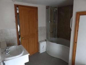 a bathroom with a tub and a sink at Crab pot cottage in Flamborough