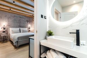 een badkamer met een bed, een wastafel en een spiegel bij Amoretta rooms in Šibenik