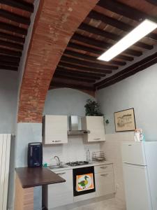 kuchnia z białymi urządzeniami i ceglanym sufitem w obiekcie La grotta nel borgo w mieście Roccastrada +14 zdjęć