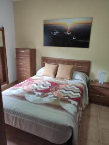 sypialnia z łóżkiem i obrazem na ścianie w obiekcie Apartamento A Nave w mieście Fisterra