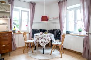 a dining room with a table and chairs and windows at Family Hideaway mit Baby- und Kleinkindausstattung in Hallstatt