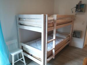 a couple of bunk beds in a room with a chair at Fietes Ankerplatz in Wangerland