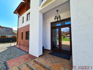 a entrance to a house with a glass door at Stejarro Conac Moldovenesc in Stejaru