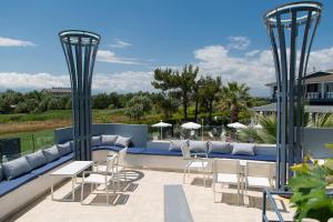 eine Terrasse mit Stühlen und Tischen auf einem Dach in der Unterkunft Anais Hotel in Korinós