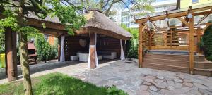 a large wooden gazebo with a thatch roof at Willa Joka in Międzyzdroje +23 photos