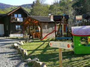 um parque infantil em frente a uma cabana de madeira em Cabana Rustic Balea em Cîrţişoara