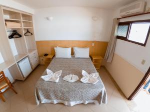 a hotel room with a bed and a dresser at Hotel Recanto dos Pássaros in São Sebastião
