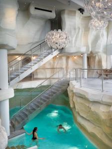 a pool in a hotel with two people in the water at Appartement Standing 5* Arc 1950 in Arc 1950