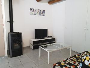 a living room with a tv and a glass table at Gite Le Maty in Saint-André-Capcèze