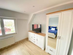 uma sala com um quarto com uma cama e um espelho em Strandliebe Markgrafenheide em Rostock