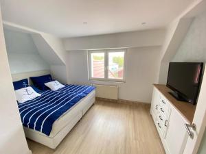 um quarto com uma cama e uma televisão de ecrã plano em Strandliebe Markgrafenheide em Rostock