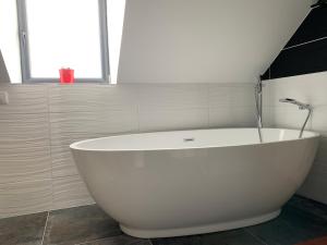 een groot wit bad in de badkamer bij Appartement 3 chambres centre ville et 100m de la mer in Concarneau