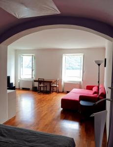 a living room with a red couch and a table at Oria Lugano Lake, il nido dell'aquila in Oria