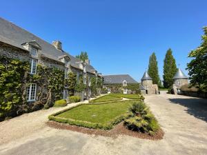 an exterior view of a house with a garden at Manoir de la Bégaudière in Mont-Dol