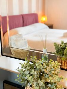 ルッカにあるCuore di Nozzano Castelloのベッド1台と植物のあるテーブルが備わる部屋