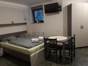 Schlafzimmer mit einem Bett und einem Tisch mit Stühlen in der Unterkunft Apartma Juteršek 2+2 in Libeliče