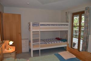 a bedroom with two bunk beds and a window at Ferienwohnung Sonnenbichel in Wertach