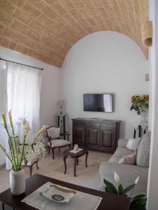 a living room with a couch and a tv at Asylum Amicorum Bed & Breakfast in Gagliano del Capo