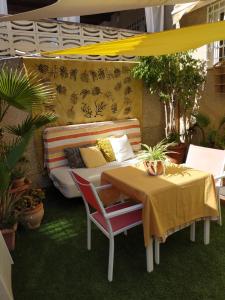 a patio with a couch and a table and chairs at La Casita de Nuria in Rincón de la Victoria