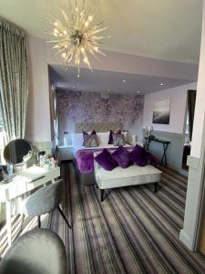 um quarto com uma cama grande e almofadas roxas em Ruskin Hotel em Blackpool